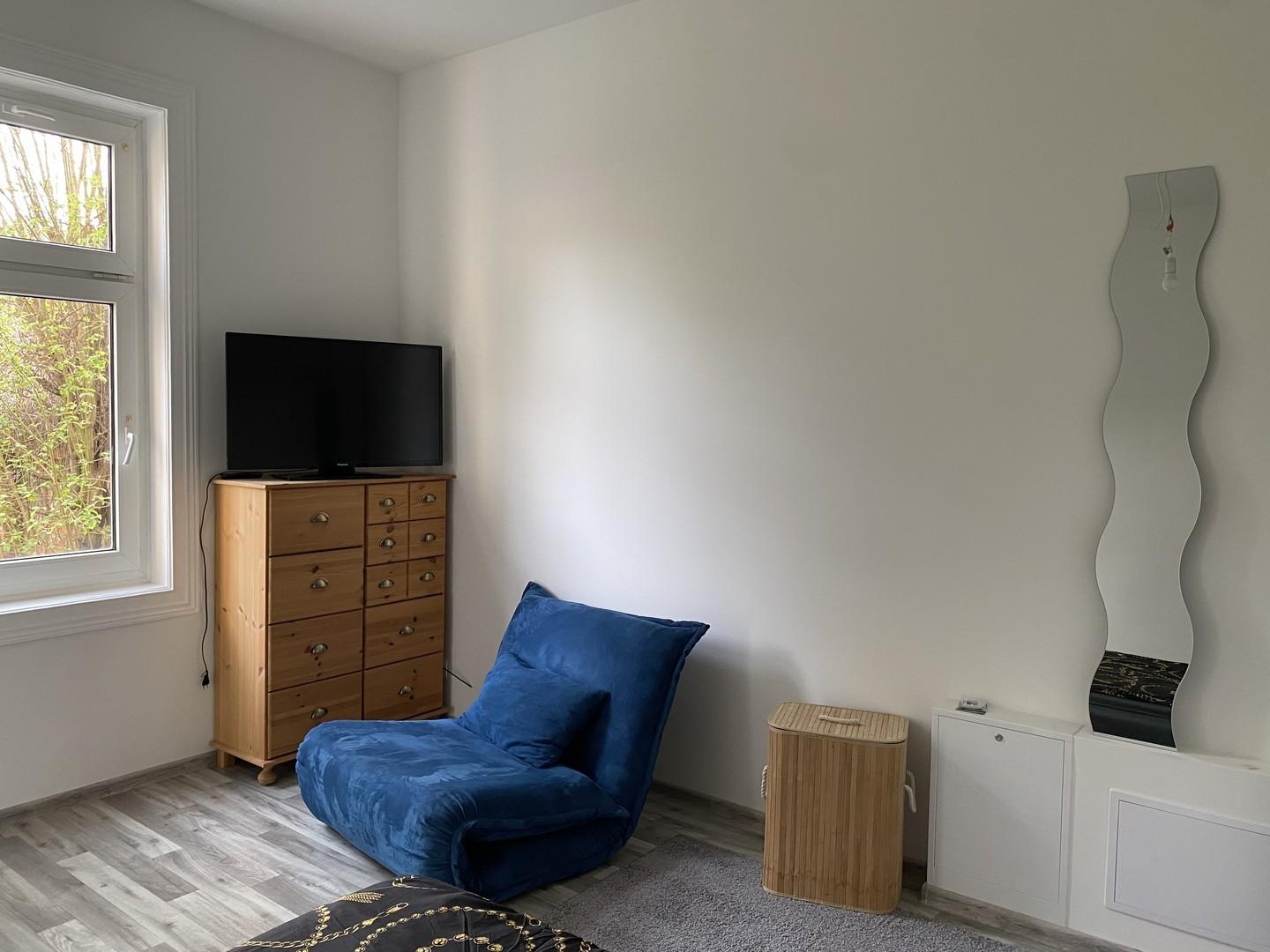 TV und Sessel mit Schlaffunkt.