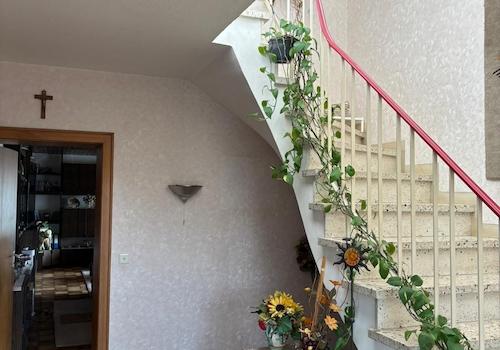 Teil der geräumigen, gefliesten Diele mit Treppe ins Obergeschoss und Tür zum Wohnzimmer