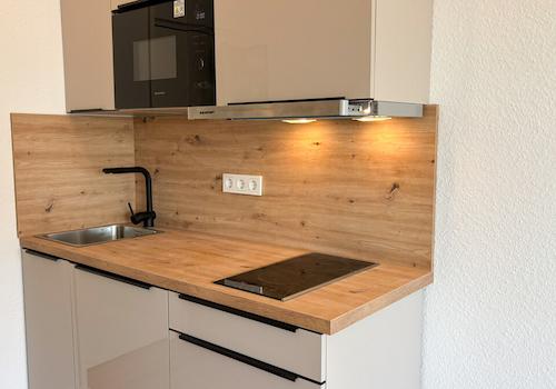 Moderne Einbauküche mit Kühlschrank, Induktionsherd und Mikrowelle