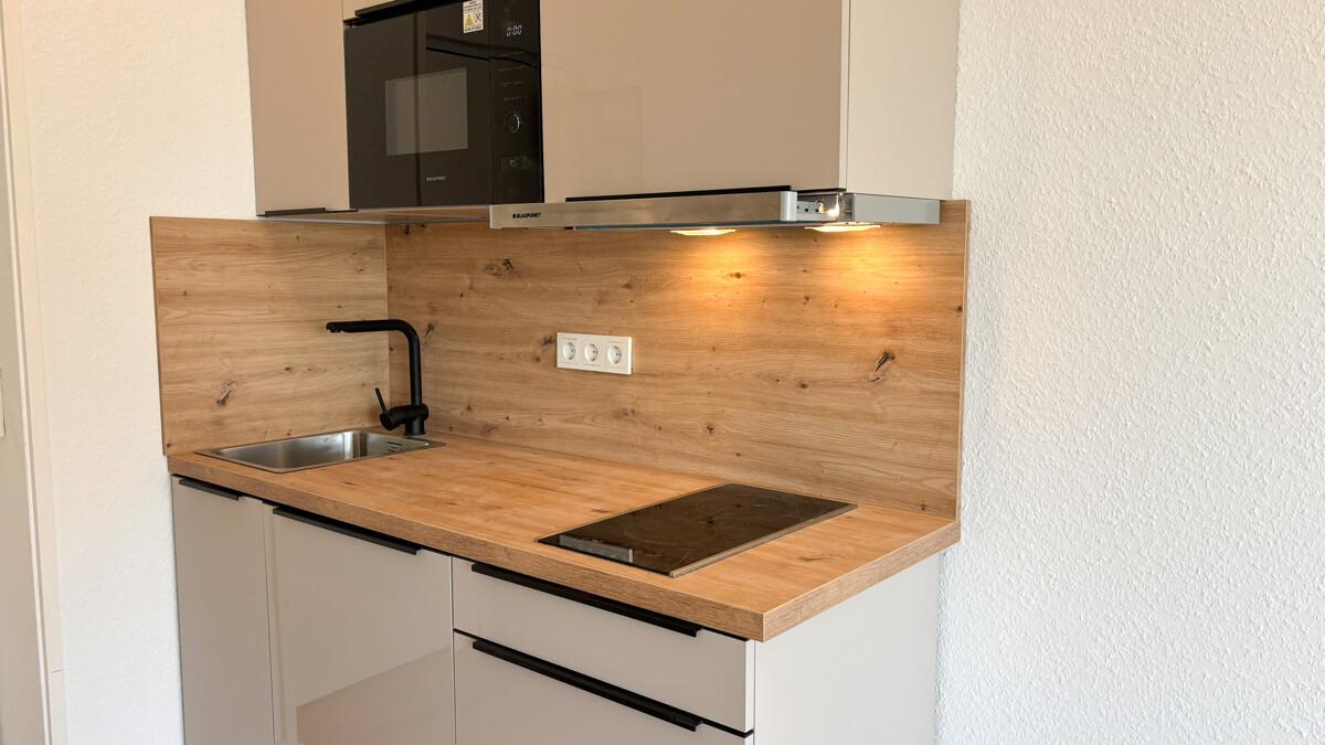 Moderne Einbauküche mit Kühlschrank, Induktionsherd und Mikrowelle