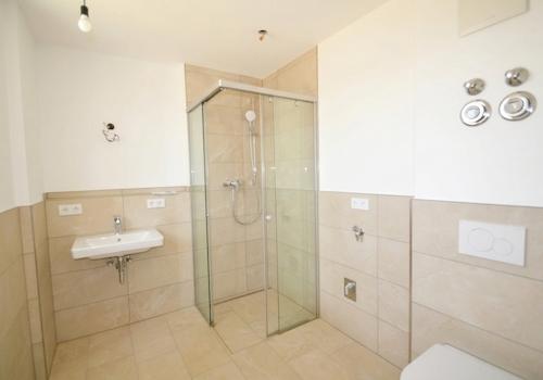 Badezimmer mit ebenerdiger Dusche und Waschmaschinenanschluss