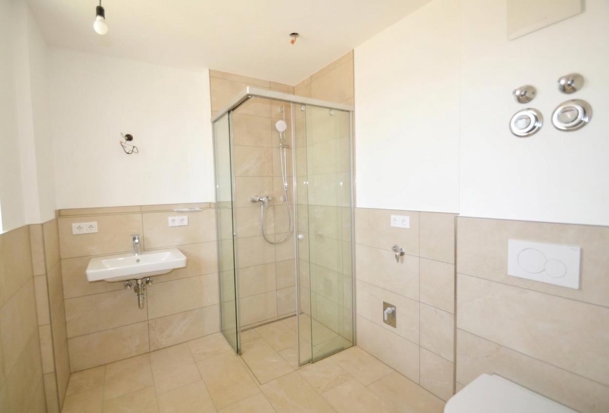 Badezimmer mit ebenerdiger Dusche und Waschmaschinenanschluss