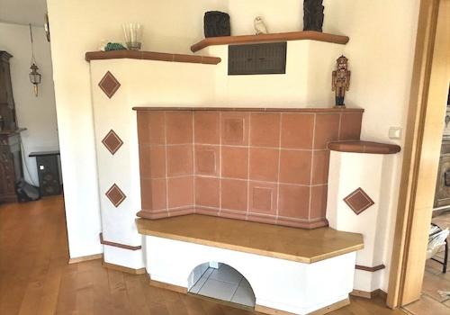 KI-generiert: gemütlicher Kachelofen (Wohnzimmer)