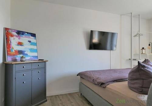 Kommode und Bett hinter dem Raumteiler