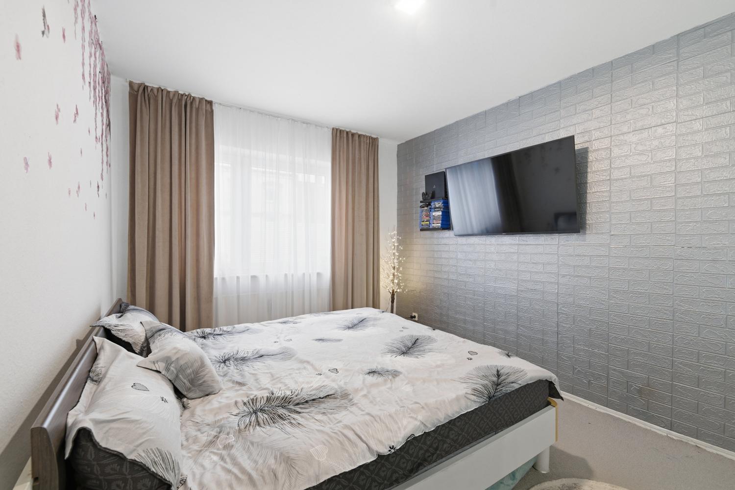 Gemütliches Schlafzimmer mit großen Fenstern