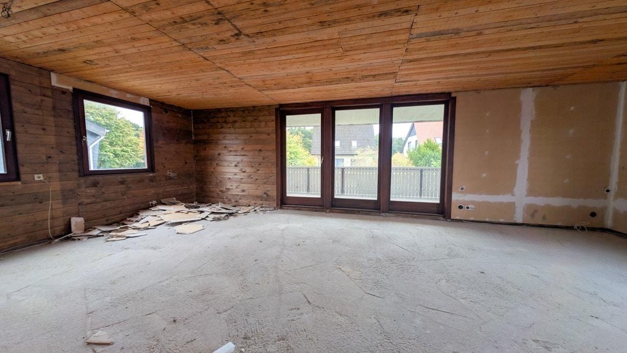 Wohn- Esszimmer mit Küchenanschlüssen und Zugang zum Balkon