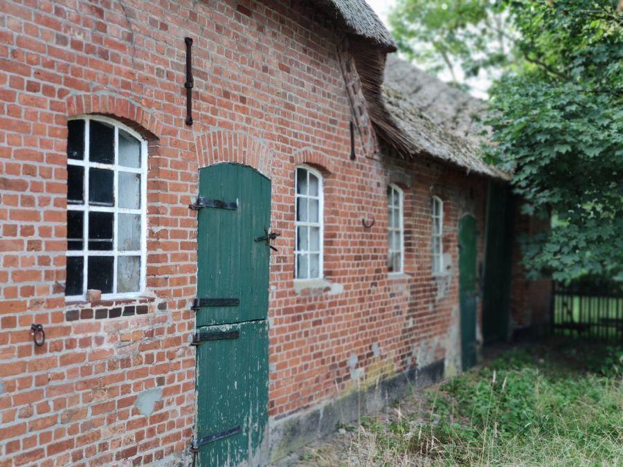 Backsteinfassade mit historischen Fenstern und Seiteneingang