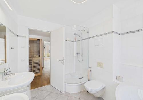 Masterbad mit Blick zur Dusche und in den Sauna-Ankleidebereich