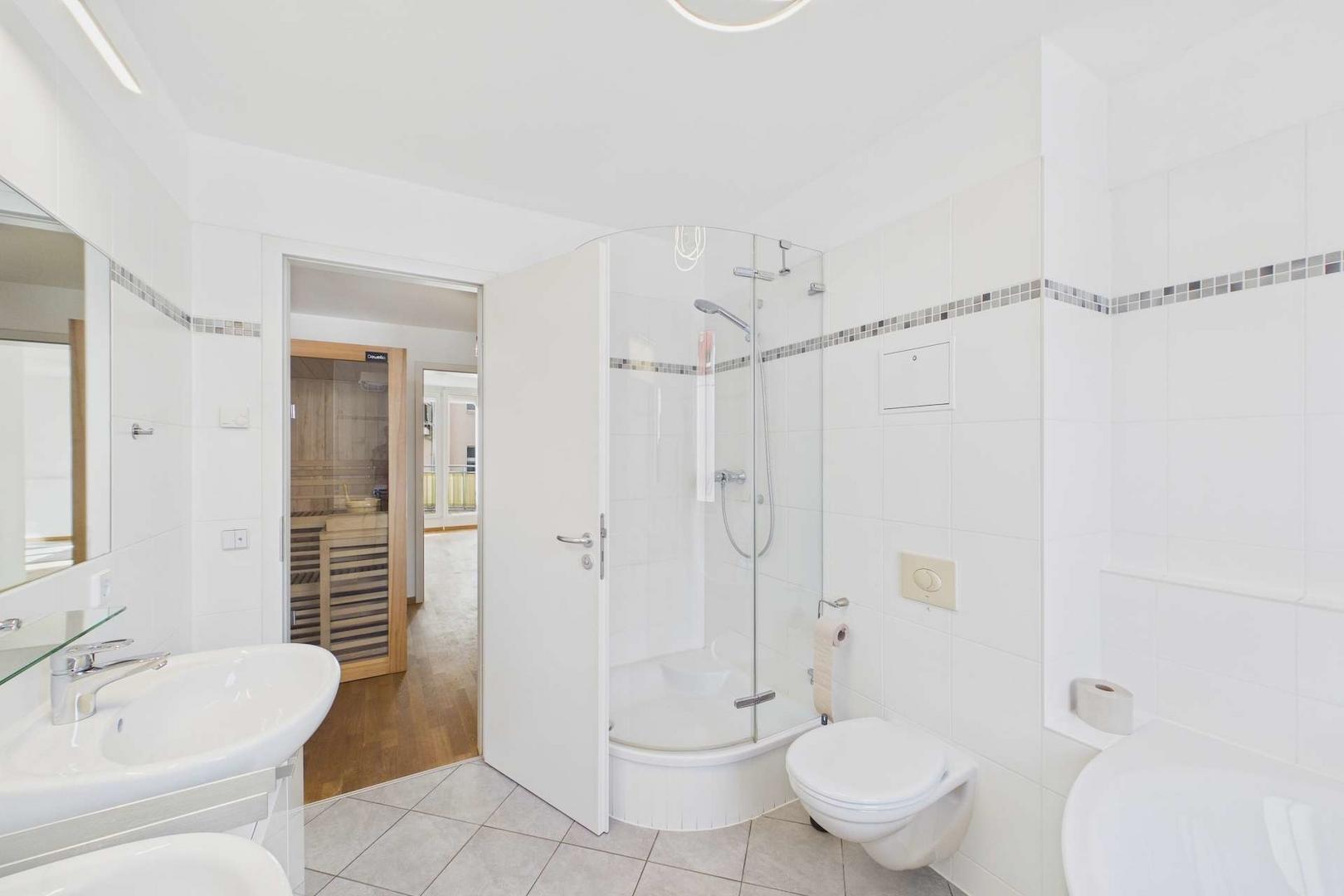 Masterbad mit Blick zur Dusche und in den Sauna-Ankleidebereich