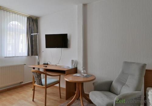 Sessel, TV und Schreibtisch