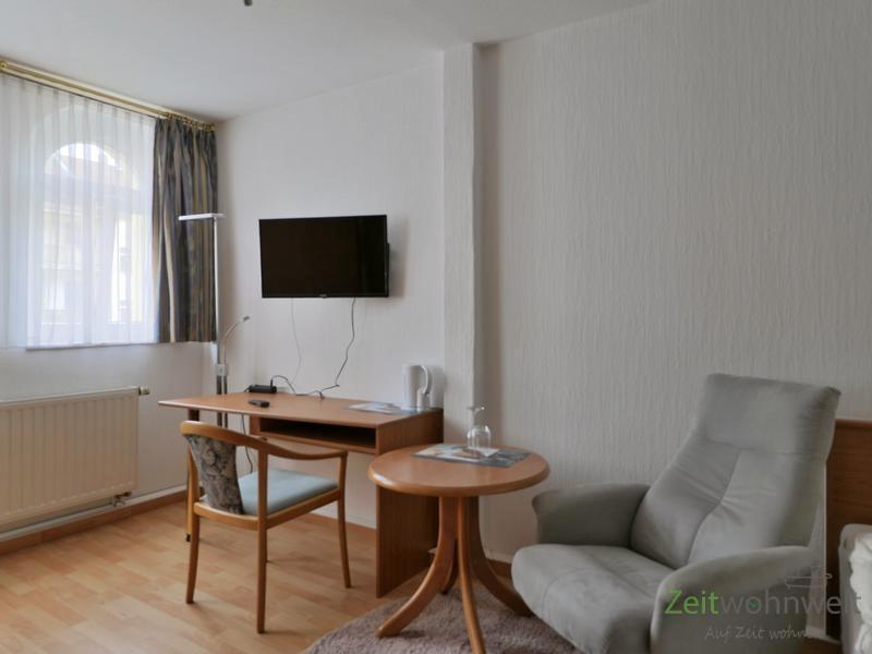 Sessel, TV und Schreibtisch