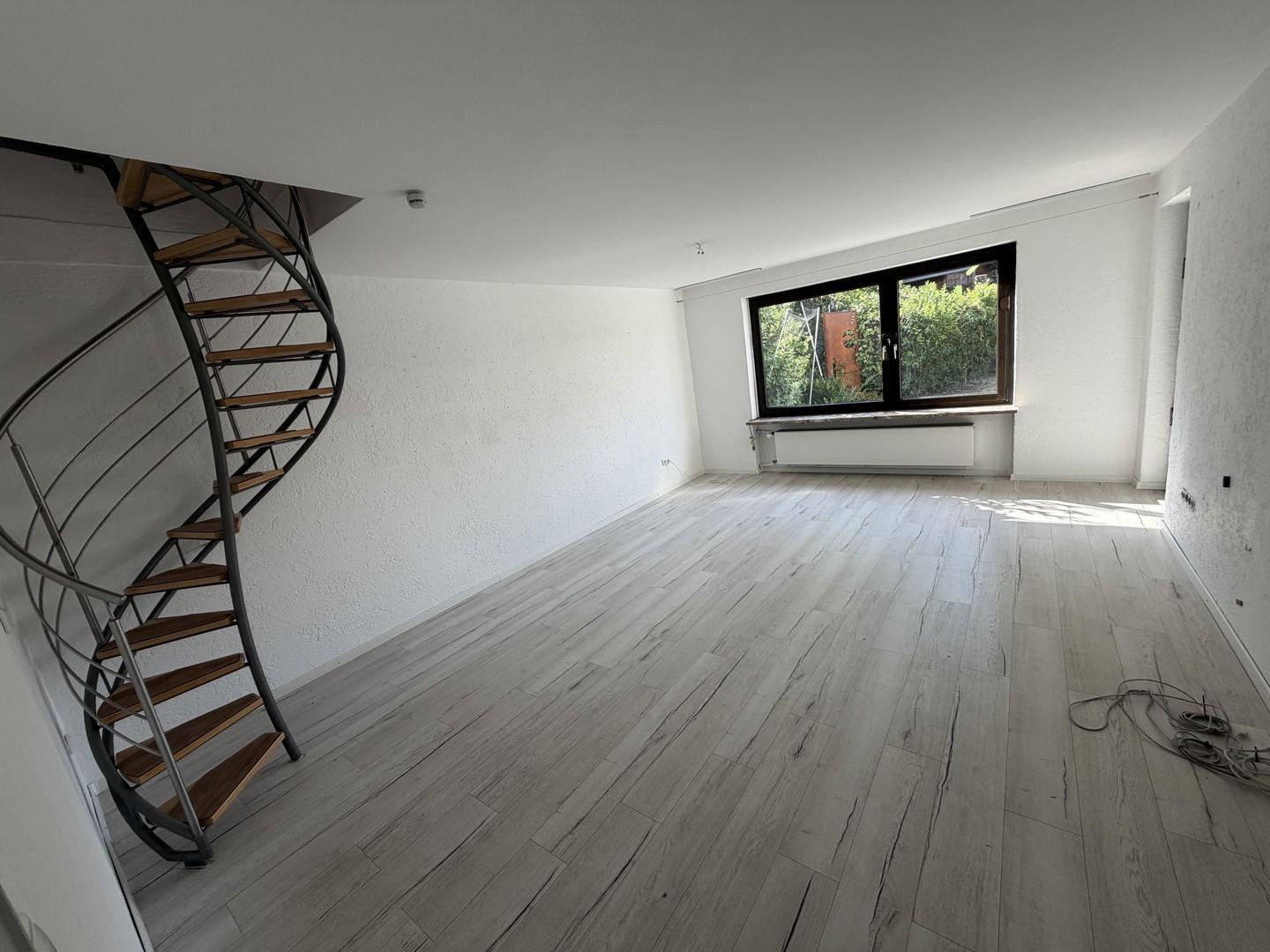 Wohnzimmer mit Wendeltreppe zu