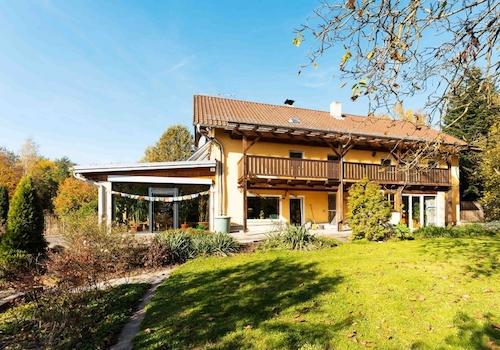 Die östliche Ansicht auf das Haus mit Balkon und Wintergarten