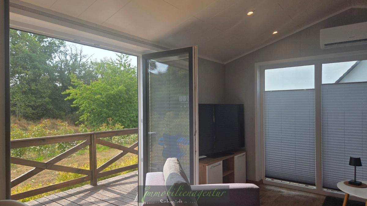 Wohnbereich mit Blick zur Terrasse ins Grüne - Original Foto