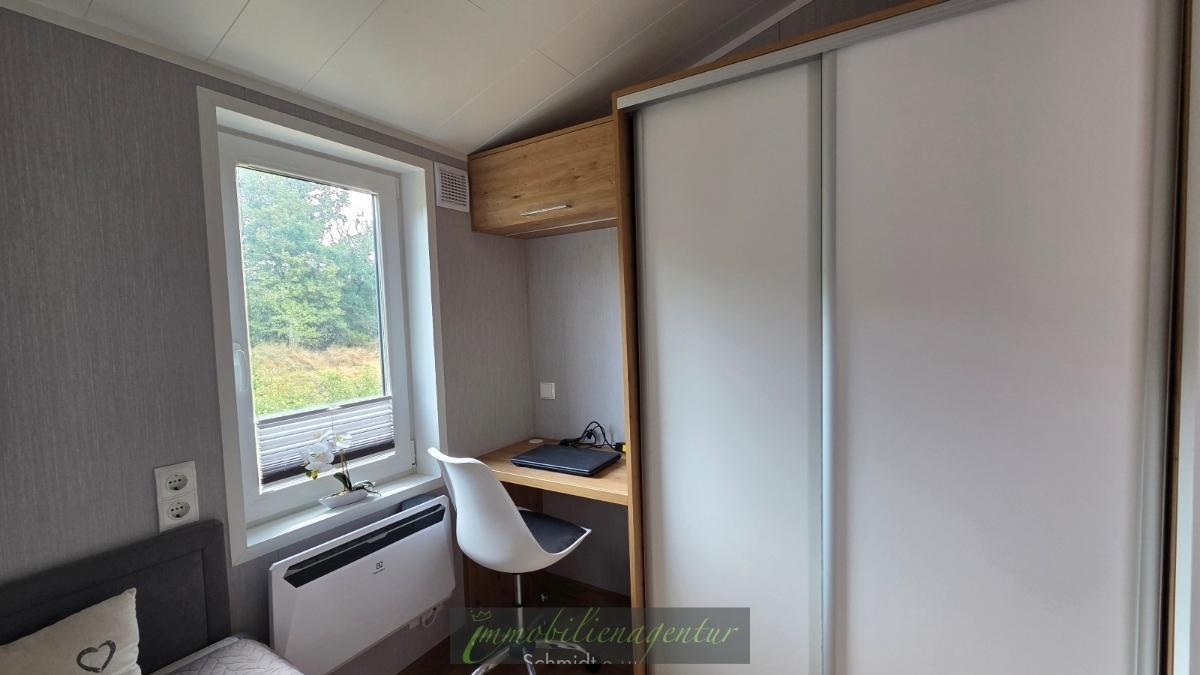 kleines Schlafzimmer mit Kleiderschrank, Tisch und Stuhl - Original Foto